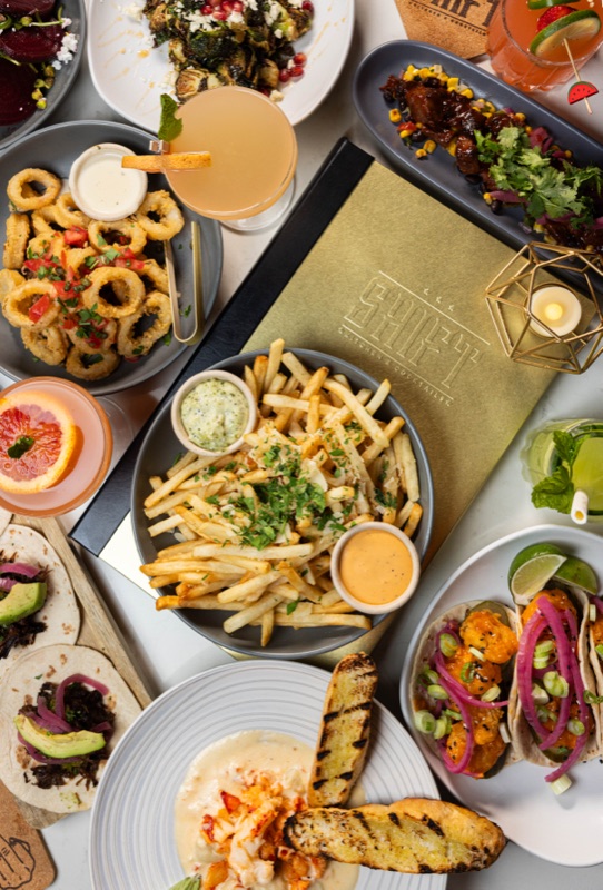 Onion rings, fries and salads spread across a table