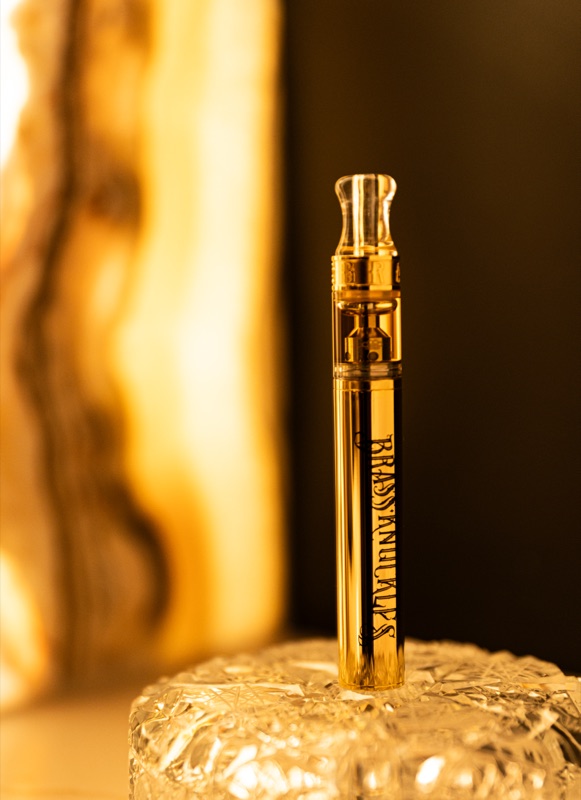 A gold cigar tube on a crystal stand