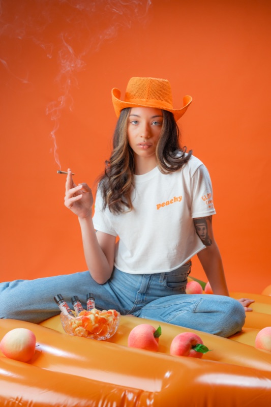 A model in an orange cowboy hat on an orange set