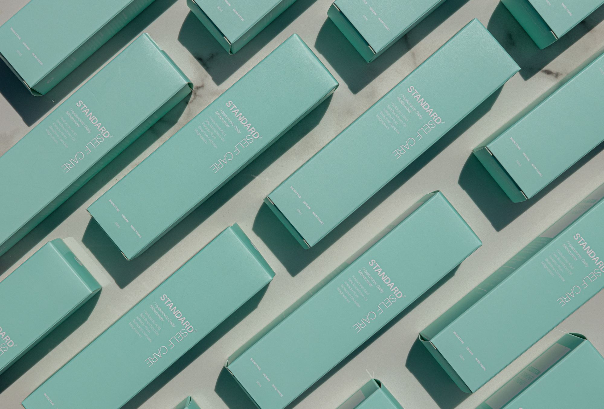 Teal skincare boxes arranged in rows and shot from above